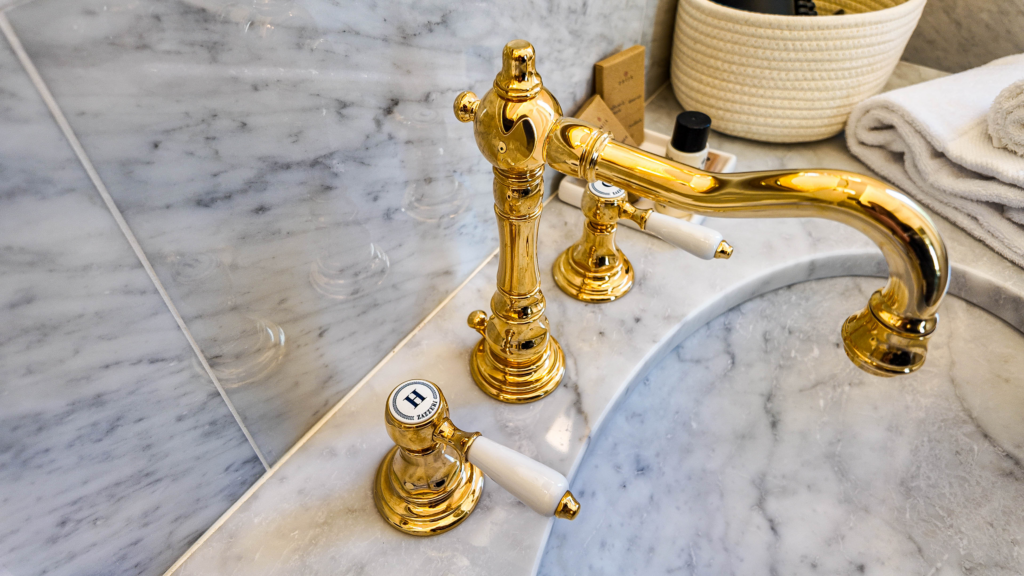 Rubinetto dorato su un lavabo in marmo