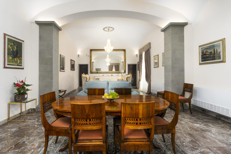 The salon with the oval walnut table and barrel-vaulted ceiling