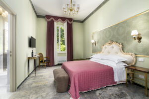 Imperial Suite: camera da letto con testiera capitonné dorata e lampadario