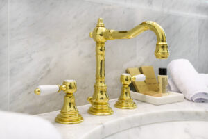 Imperial Suite: rubinetteria dorata su lavabo in marmo e prodotti di cortesia