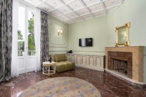 Suite Prestige con Balcone: angolo salotto con camino in marmo e portefinestre