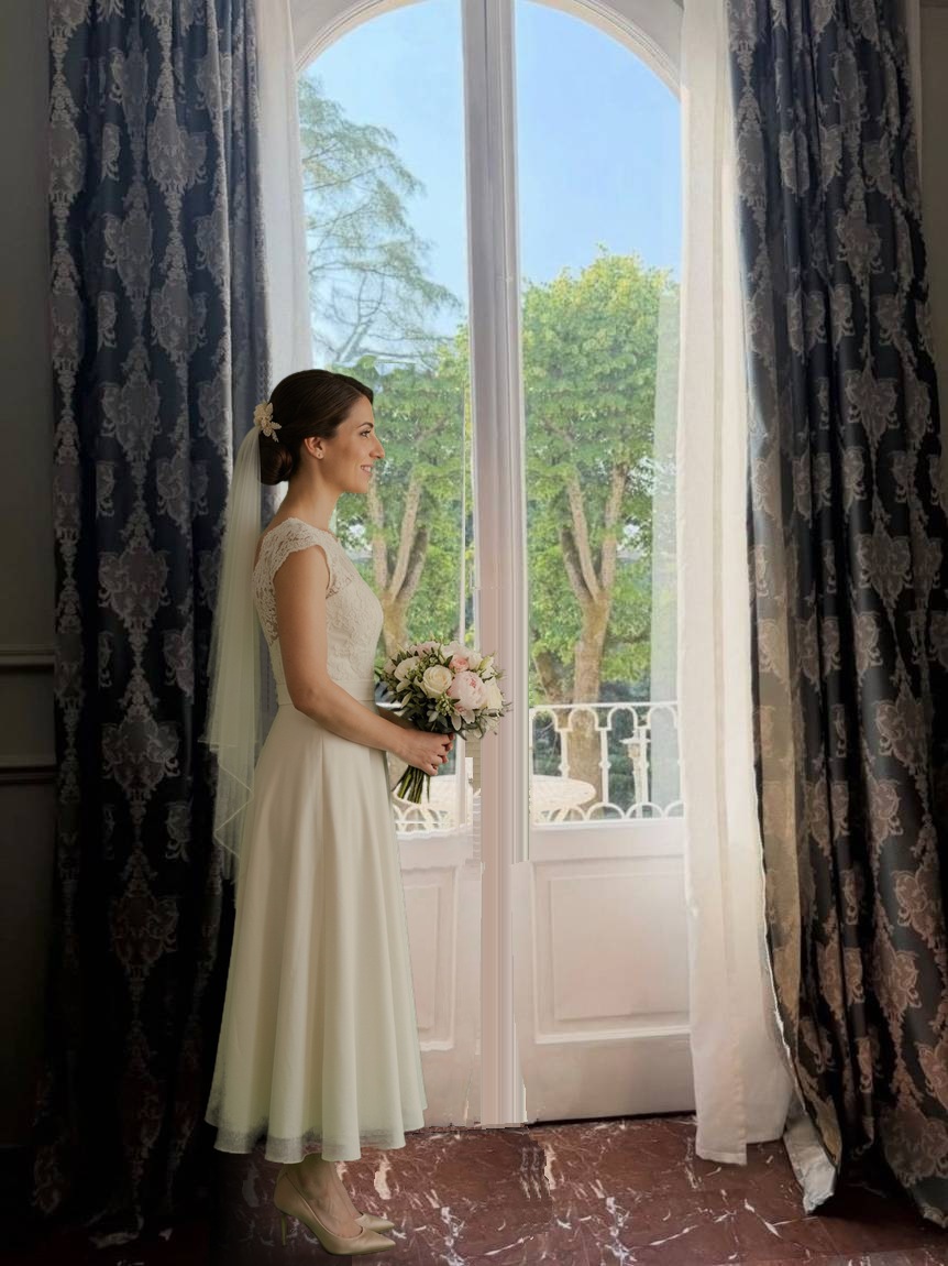Sposa con velo e bouquet di rose bianche davanti alla portafinestra ad arco di una suite di Villa L'Avvenire a Siena, aperta sul balcone e sul parco (figura della sposa creata con intelligenza artificiale).
